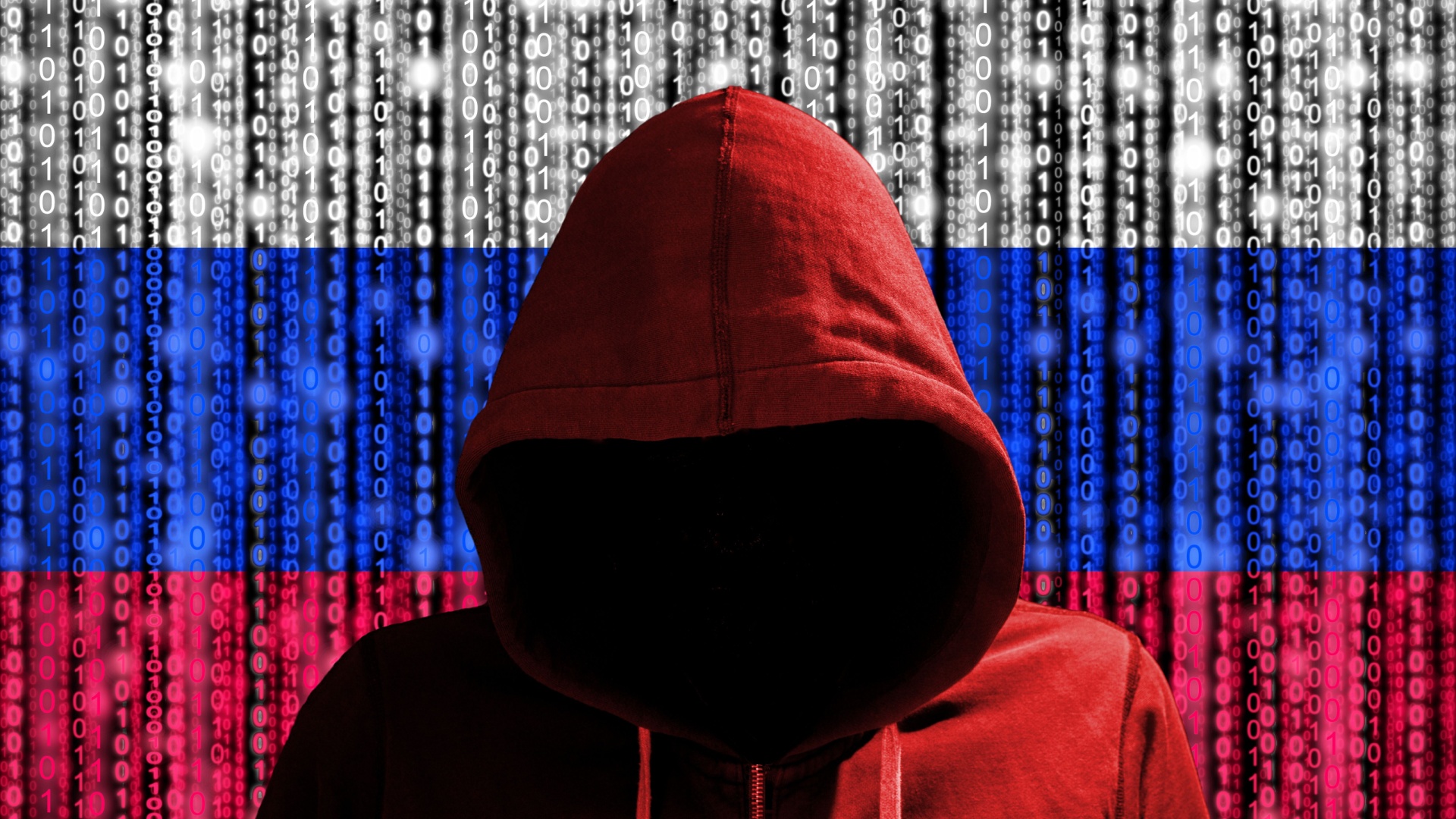 Hacker in a dark red hoody in front of a digital russian flag and binary streams background cybersecurity concept